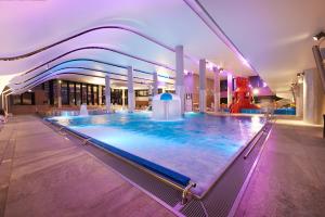 a large indoor swimming pool in a building at VacationClub - Aquamarina Apartment C-05 in Świnoujście