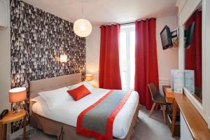 a bedroom with a bed and a desk and red curtains at The Originals Boutique, Hôtel Victoria, Fontainebleau in Fontainebleau