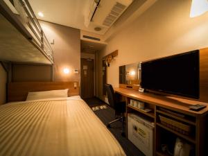Super Hotel Aomori في أوموري: غرفة فندقية بسرير وتلفزيون بشاشة مسطحة