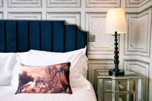 a bed with a pillow and a lamp on a table at Rowan Tree - Your Apartment in Bristol