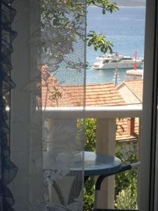 a window with a view of a boat in the water at APARTMAN BRIGIT - CENTAR in Bol