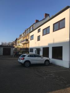ein Auto, das auf einem Parkplatz neben einem Gebäude parkt in der Unterkunft Living @ Klassvilla Weserwehr No. 4 in Bremen