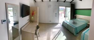 a bedroom with a bed and a desk in a room at Club Esse Cala Bitta in Baja Sardinia