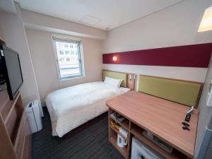 a small room with a bed and a desk at Super Hotel Aomori in Aomori