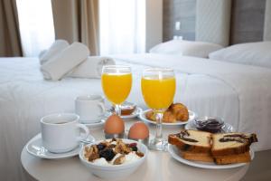 un vassoio per la colazione con uova e pane tostato e 2 bicchieri di succo d'arancia di Metropolitan a Salonicco