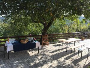 a table and chairs sitting on a patio under a tree at Casa Vacanze La Stele in Castelmonte
