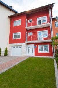 una casa roja con césped delante en NADA, en Karlovac