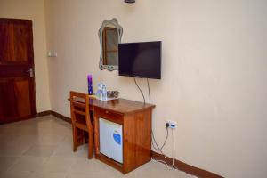 a living room with a tv on a wall at Zanzibar Ocean View Hotel in Zanzibar City