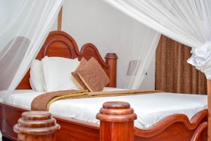 1 dormitorio con cama de madera y dosel en Zanzibar Ocean View Hotel en Zanzíbar