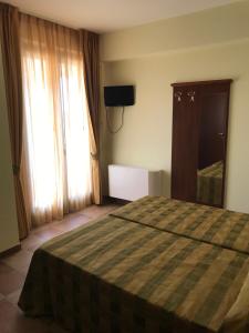 a bedroom with a bed and a television and a window at Il Podere del Carlone in Vasto