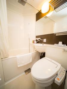 a bathroom with a white toilet and a bath tub at Super Hotel Aomori in Aomori