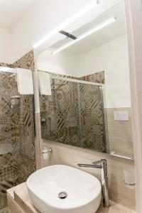ein Bad mit einem Waschbecken und einem Spiegel in der Unterkunft B&B Maremy... I 4 Elementi in Neapel