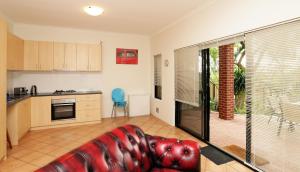 a living room with a red couch in a kitchen at 230 Alice Street in Perth