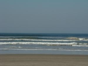 a person walking on the beach near the ocean at Pousada Y-Goá in Bertioga