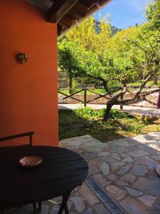 patio con tavolo e vista su un albero di Ilaeira Mountain Resort a Tóriza