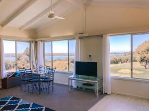 sala de estar con mesa, sillas y ventanas en Paradise View en Augusta