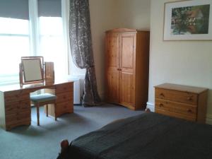 a bedroom with a bed and a dresser and a window at Avenue Road in Gateshead