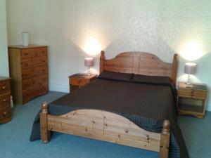 a bedroom with a large wooden bed with two night stands at Avenue Road in Gateshead +11 photos
