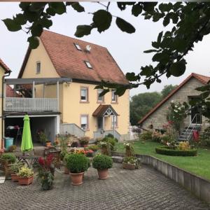 ein Haus mit einer Terrasse und Pflanzen davor in der Unterkunft Ferienwohnung Angelika Gries in Margetshöchheim