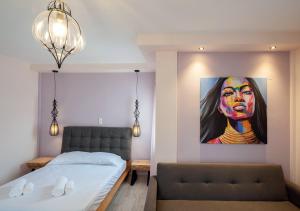 a bedroom with a bed and a painting of a woman at Iliovasilema in Platy