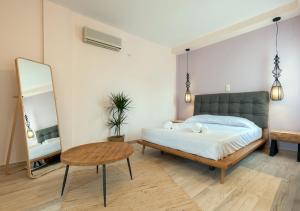 a bedroom with a bed and a table and a mirror at Iliovasilema in Platy