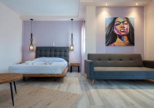a bedroom with a bed and a couch and a painting at Iliovasilema in Platy