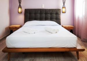 a bed with two white towels on top of it at Iliovasilema in Platy