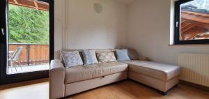 a living room with a couch and a window at Apartment Alpska Astra in Kranjska Gora