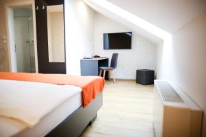 ein Schlafzimmer mit einem Bett und einem Schreibtisch mit Fernseher in der Unterkunft Ambient Hotel in Domžale