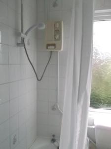 een badkamer met een douche met een wit douchegordijn bij Freshwater Bay, 138 in Hodgeston
