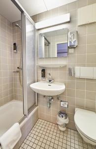 a bathroom with a sink and a shower and a toilet at HarzHotel Güntersberge in Güntersberge