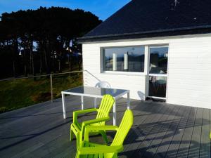deux chaises jaunes et une table sur une terrasse dans l'établissement Residence du Fou, à Trévou-Tréguignec
