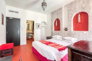 1 dormitorio con 1 cama grande con detalles en rojo en Le Ryad Boutique Hôtel, en Marsella