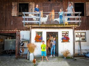 Herdwangen-SchönachにあるFerienwohnung Kapellenhofの馬の納屋外に立つ一族