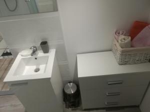 ein weißes Badezimmer mit einem Waschbecken und einer Theke in der Unterkunft Obiteljski Apartmani Švob Lavanda & Ružmarin sa pogledom na more in Novi Vinodolski