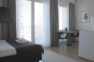 a hotel room with a bed and a desk and window at Forenom Serviced Apartments Rovaniemi Valtakatu in Rovaniemi