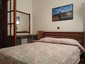 a bedroom with a bed and a mirror on the wall at Athina's Guesthouse in Rethymno