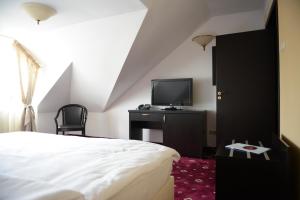 een hotelkamer met een bed en een televisie bij Hotel Bulevard Predeal in Predeal