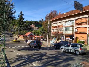 una calle en una ciudad con coches aparcados en la carretera en ap 101, en Gramado