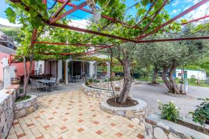 a patio with trees and a stone wall at Sumice Inn in Petrovac na Moru