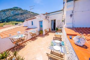 a patio with tables and chairs on a building at Casanova Rooms and Apartment to Rent in Cefalù