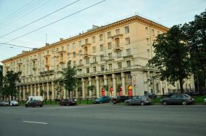 un gran edificio con coches estacionados frente a él en Metro-Tour Hostel, en San Petersburgo