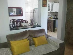 a living room with a couch with two yellow pillows at Casa & Hospedagem Carol in Cachoeira Paulista