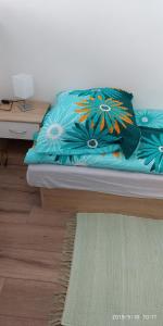 a bed with a blue blanket with flowers on it at WHITE CORAL CLUB in Košice +40 photos