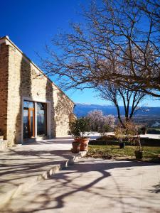 un edificio in mattoni con una porta e un albero di La Bastide du Limon a Mormoiron