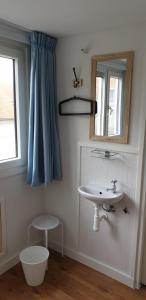 un baño con lavabo y espejo en Egmont op zee, en Egmond aan Zee
