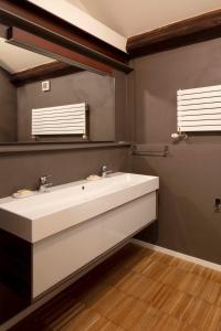 bagno con lavandino bianco e specchio di Mitodea - Residenza d'Epoca a Bologna