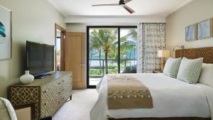 a bedroom with a large bed and a television at Timbers Kauai Ocean Club & Residences in Lihue +92 photos