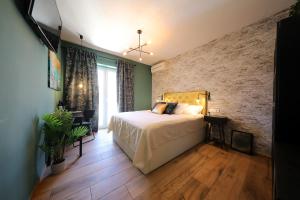 a bedroom with a bed and a brick wall at Aldo Apartments Center in Zadar