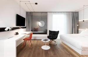 a bedroom with a bed and a desk and a chair at KPM Hotel & Residences in Berlin